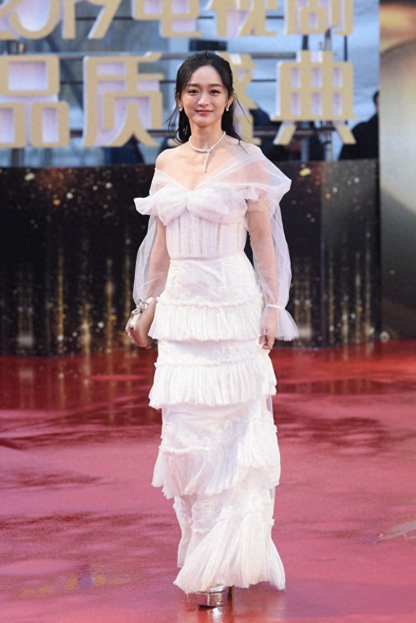 何泓姗一袭白色抹胸薄纱裙梦幻唯美，曼妙身姿与优雅气质让人惊艳